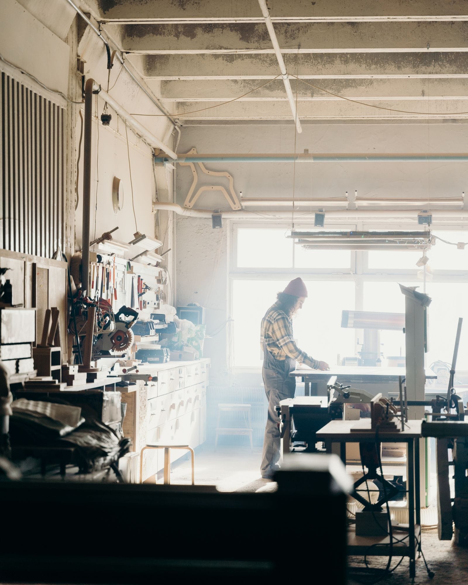 A person working at a bench in a sunlit workshop